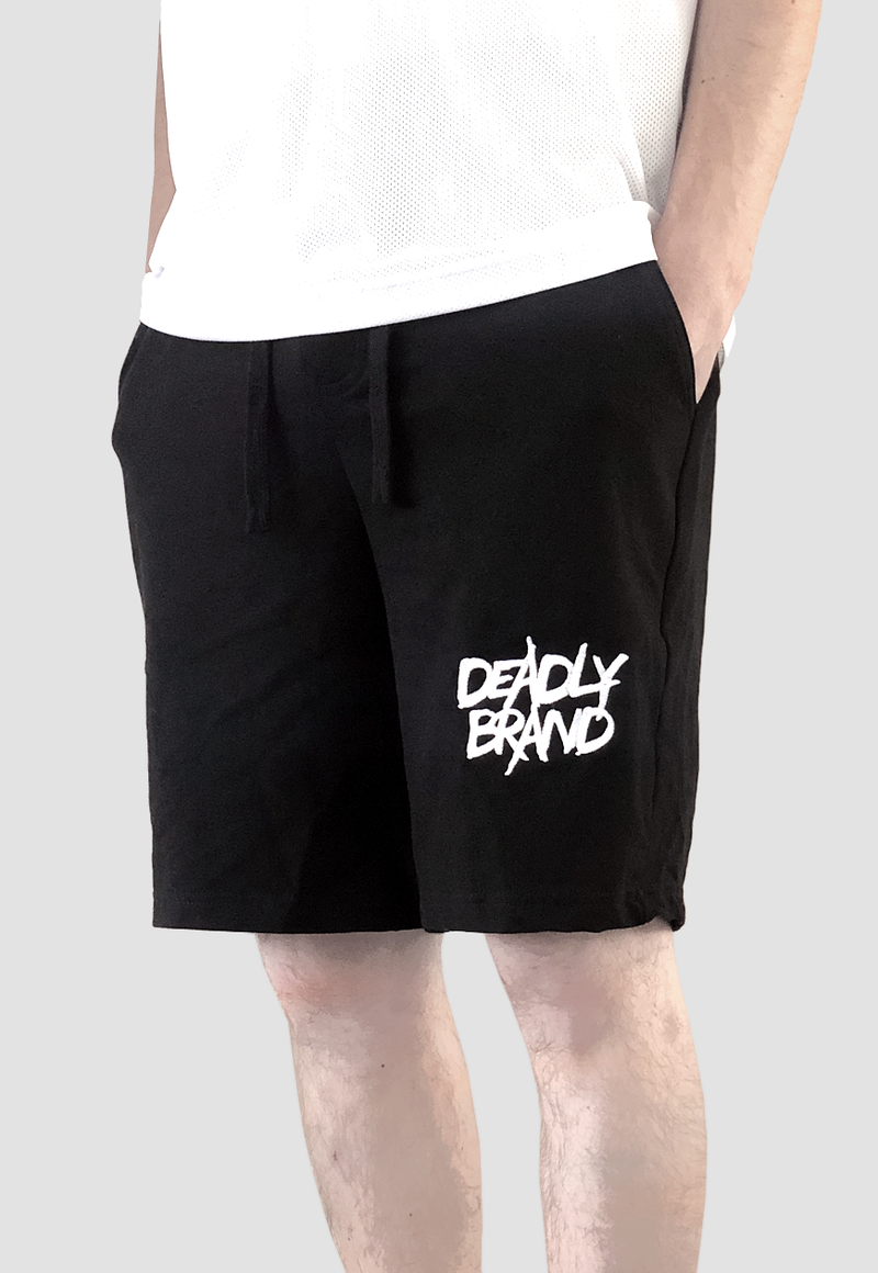 DEADLY BRAND® TRASHY logo embrodiered in white on the front of a pair of black shorts